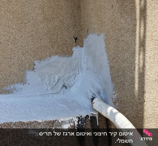 צינור אטום בחומר לבן על קיר חיצוני